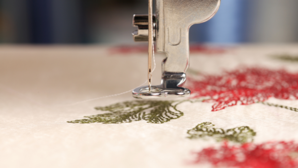Embroidery needle stitching a floral sample reference Embroidery needle stitching a floral sample reference